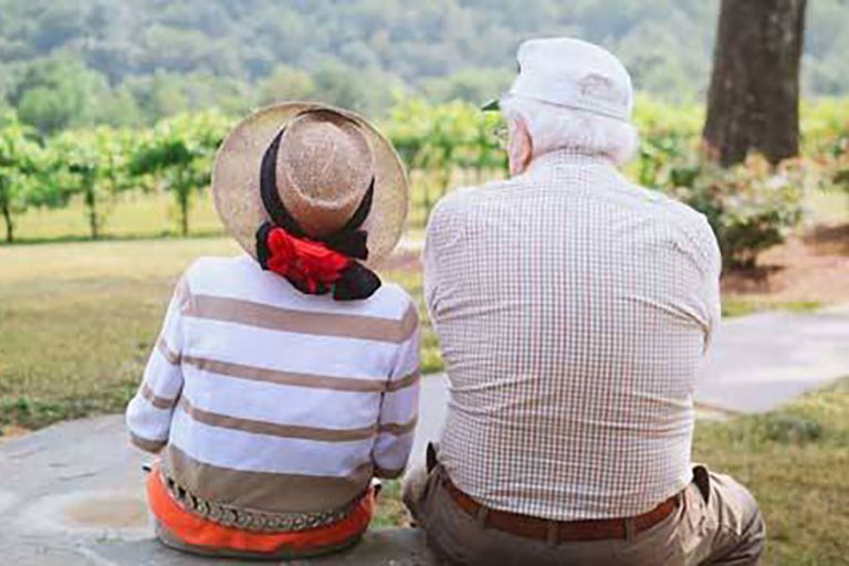Elderly Couple Sitting Together On A Bench